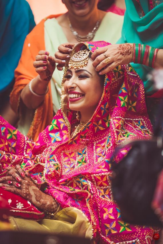 Bride wearing vivid Phulkari in an editorial portrait